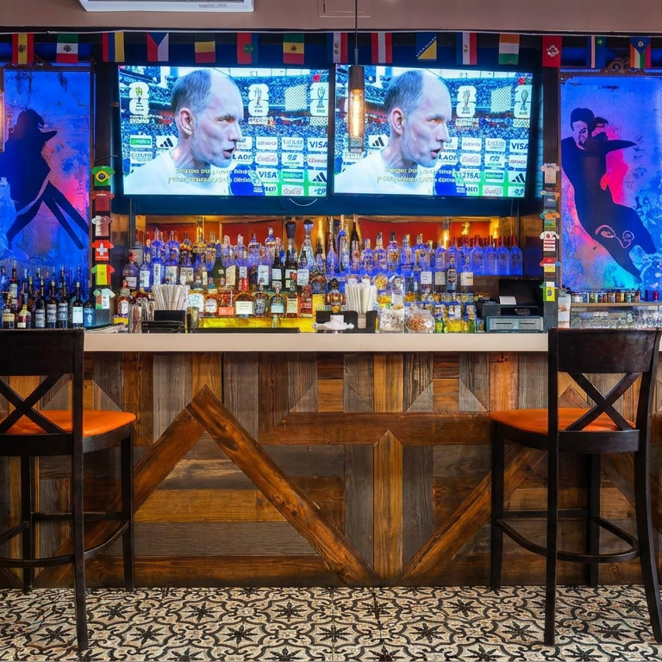 Vibrant bar interior with wooden counter, colorful liquor bottles, high chairs, international flags, and sports playing on televisions.